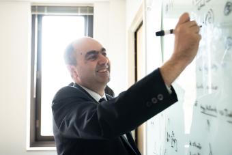 Professor writing on white board