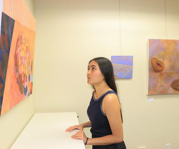 student looking at art in gallery