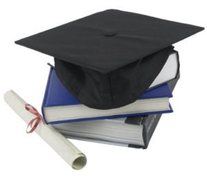 Mortarboard sitting on pile of books next to rolled up diploma